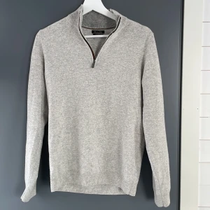 Massimo Dutti wool och cashmere halfzip  - Snygg och stilren grå tröja från Massimo Dutti i en mjuk ull- och kashmirblandning. Tröjan har en praktisk dragkedja vid halsen och ribbade muddar vid ärmslut och nederkant. Perfekt för en elegant och bekväm look. Skick 9/10 knappt använd. Tvek inte att skriva vid eventuella frågor 