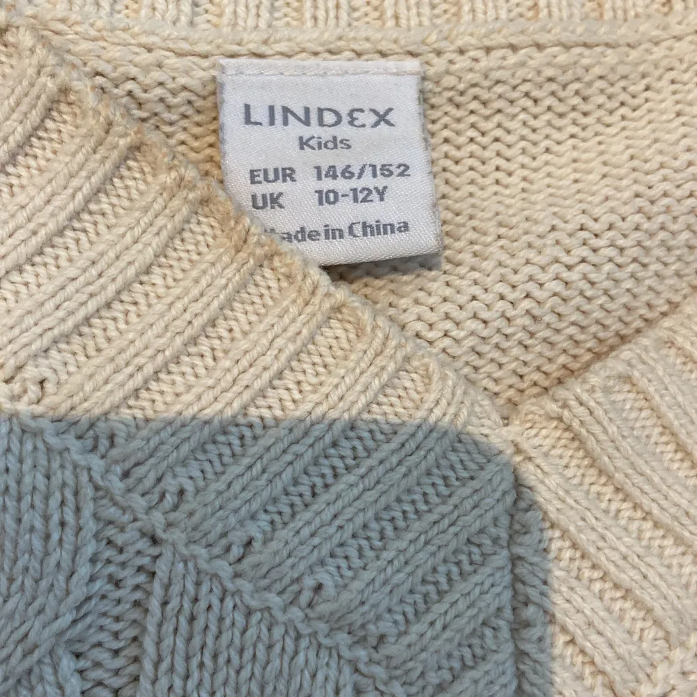 Säljer en mysig vit/beige stickad tröja från Lindex med ett klassiskt flätmönster. Tröjan har en v-ringad hals och långa ärmar med ribbade muddar. Perfekt för kyliga dagar!. Neuletakit & Villapaidat.