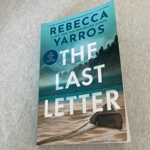 The Last Letter - Boken 'The Last Letter' av Rebecca Yarros är en känslosam roman som har fått uppmärksamhet på TikTok. Omslaget visar en dramatisk kustlinje med havsvågor och en hundtagg i förgrunden. Perfekt för dig som gillar gripande berättelser.