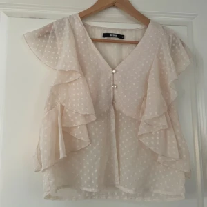 Volangblus  - Säljer en söt vit blus från Bik Bok med prickigt mönster och volangdetaljer längs ärmarna. Storleken är M men skulle säga att den passar S!💛🩷