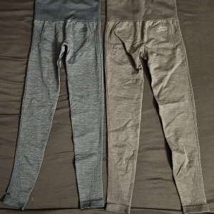 Sömlösa träningstights från Pursue Fitness - Två par sömlösa träningstights från Pursue Fitness i grå och blå nyans. Hög midja och ribbade detaljer längs benen. Perfekta för gymmet eller löpning, med tight passform och stretchigt material.