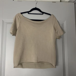 Beige ribbad kortärmad topp - Säljer en enkel och stilren beige topp med korta ärmar och rund halsringning. Toppen är ribbad och har en lagom tajta passform, perfekt att matcha med jeans eller kjol till sommaren.
