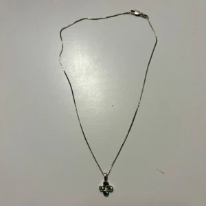 Silverhalsband  - Säljer ett tunt silverhalsband med ett hänge i form av ett fyrklöver. Både kedjan och hänget är stämplad 925 vilket betyder äkta silver. Perfekt accessoar för dig som gillar stilrena smycken. Bra skick, kan däremot behövas putsas upp för att få silvret att glänsa mer.