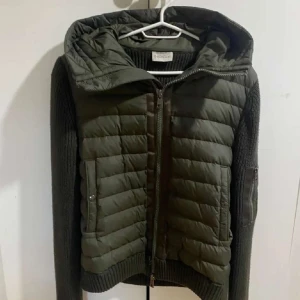Grön jacka från Moncler - Snygg grön jacka från Moncler med quiltad design och stickade ärmar.  Är öppen för att göra byte med!!