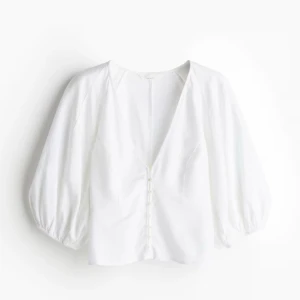 Vit blus med knappar - Säljer en stilren vit blus med v-ringning och knappar framtill. Blusen har trekvartsärmar.