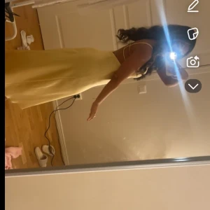 Gul satinklänning med smala axelband zara - Säljer en ljusgul långklänning i satin med smala axelband och öppen rygg med flera banddetaljer. Klänningen har en elegant v-ringning och ett mjukt, glansigt material som faller snyggt. Perfekt för sommarens speciella tillfällen. Slutsåld o är i strkl S