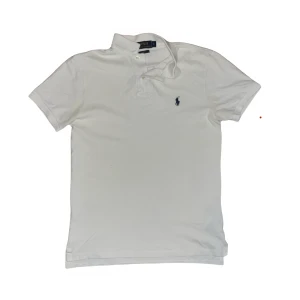 Vit Polo Ralph Lauren pike - Piken har burits noll gånger eftersom den var för liten för mig. Den är i väldigt bra skick och är nytvättad och nyskruken. Som det står på etiketten så är den slimfit. Hör av er vid övriga frågor!
