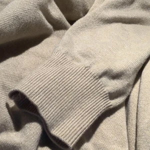 Beige merinoull luvtröja - Säljer en beige merinoull hoodie med huva. På bild ser den mer grå och svag ut men i verkligheten är den mer färgglad med starkare färg av beige. Tröjan har långa ärmar och ribbade muddar vid ärmslut och nederkant. Perfekt för en avslappnad och stilren look. Finns det frågor är det bara att ställa!