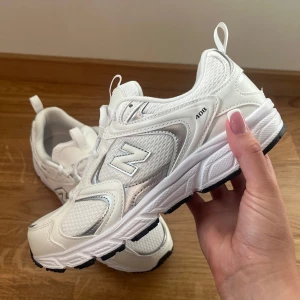 Vita New Balance 408 sneakers - Säljer ett par helt nya vita New Balance 408 sneakers med klassisk design. Skorna har meshpaneler för extra andningsförmåga, vita snören och svarta detaljer på sulan. Perfekta för dig som gillar stilrena och bekväma sneakers.