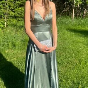 Grön balklänning  - Mycket fin balklänning! Använd en gång och kemtvättar efter det, den är som ny! Modellen är 176 cm lång och har vanligtvis storlek S i kläder och W26 i midjan. Nypris 3.200kr 