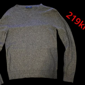 Mörkgrå stickad tröja från Jack & Jones - Säljer en mörkgrå stickad tröja från Jack & Jones i storlek XS. Tröjan har v-ringad hals och långa ärmar, perfekt för lager-på-lager eller som den är. Enkel och stilren design som passar till det mesta.