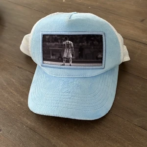 Ljusblå keps från FORTE Limited Edition - Säljer en ljusblå keps från FORTE Limited Edition med vit mesh baktill och ett svartvitt foto av en fotbollsspelare på framsidan. Kepsen har böjd skärm och justerbar passform. Perfekt för dig som gillar sportig stil. Nypris=600kr, Mitt pris=149kr Vid fundering kring prudukten eller priset så är det bara att dma oss😊        M.V.H//////// Avn Closet🍾🍾
