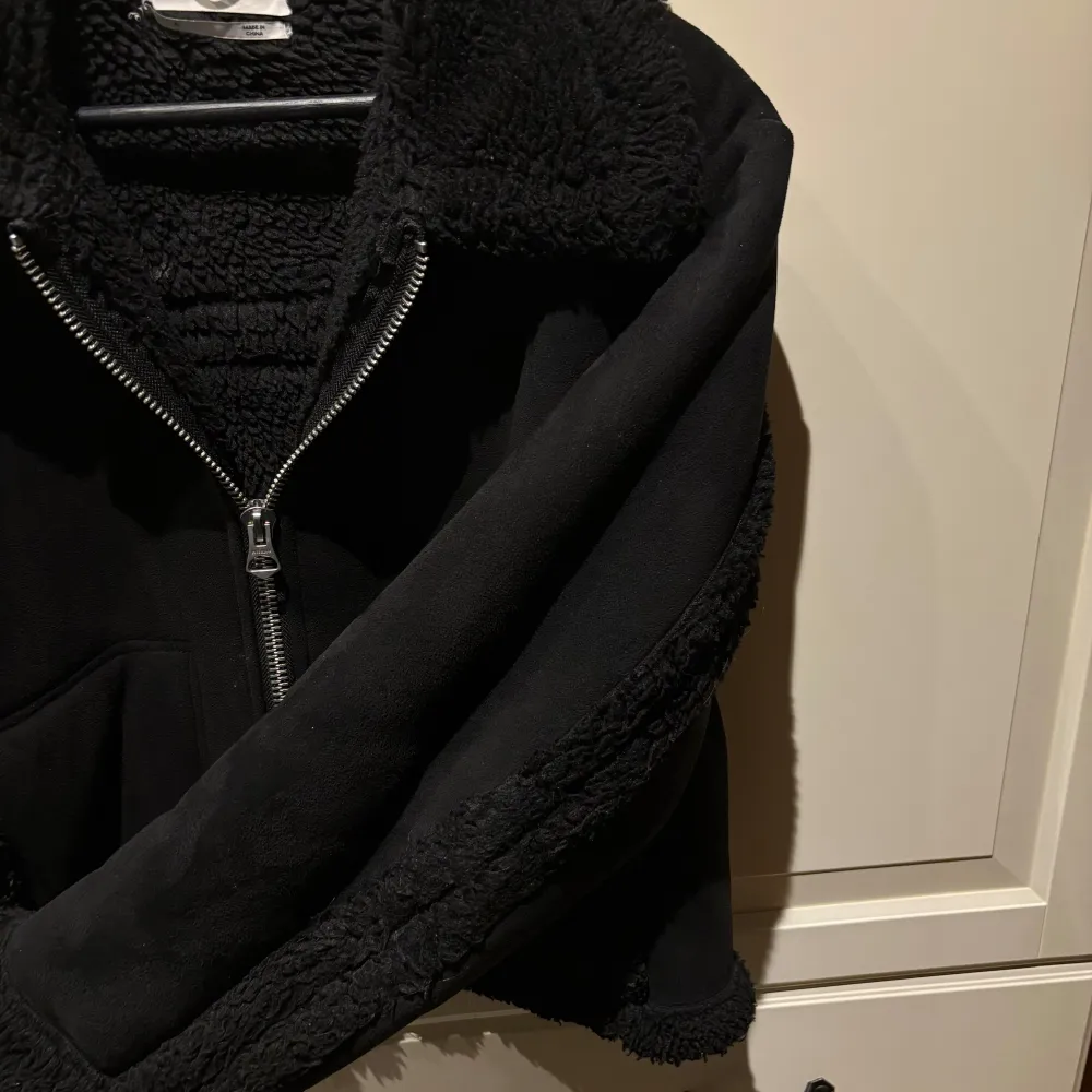 Säljer en snygg svart teddyjacka från Weekday med dragkedja framtill. Storlek S. Jackan har en mysig krage och muddar i teddy-material samt två praktiska fickor. I bra men använt skick. Nypris 1100kr! Hör av er för fler bilder/frågor!💗. Takit.