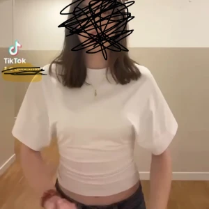 Vit t-shirt - Snygg vit t-shirt med tre kvart armar med figurnära passform i midjan.