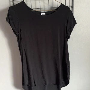Svart topp från Vero Moda - Säljer en stilren svart topp från Vero Moda. Toppen har korta ärmar och en rund halsringning. 