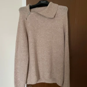 Beige stickad tröja med dragkedja - Säljer en mysig beige stickad tröja med en unik dragkedja vid kragen. Jättefint skick, pris kan diskuteras. Nypris 700kr