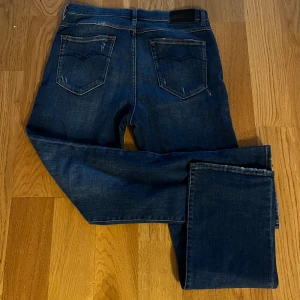 Mörkblå jeans från Replay - Snygga mörkblå jeans från Replay med klassisk femficksdesign och knappgylf. Perfekta för en avslappnad stil. Skriv vid minsta fundering och priset är diskuterbart vid snabb affär