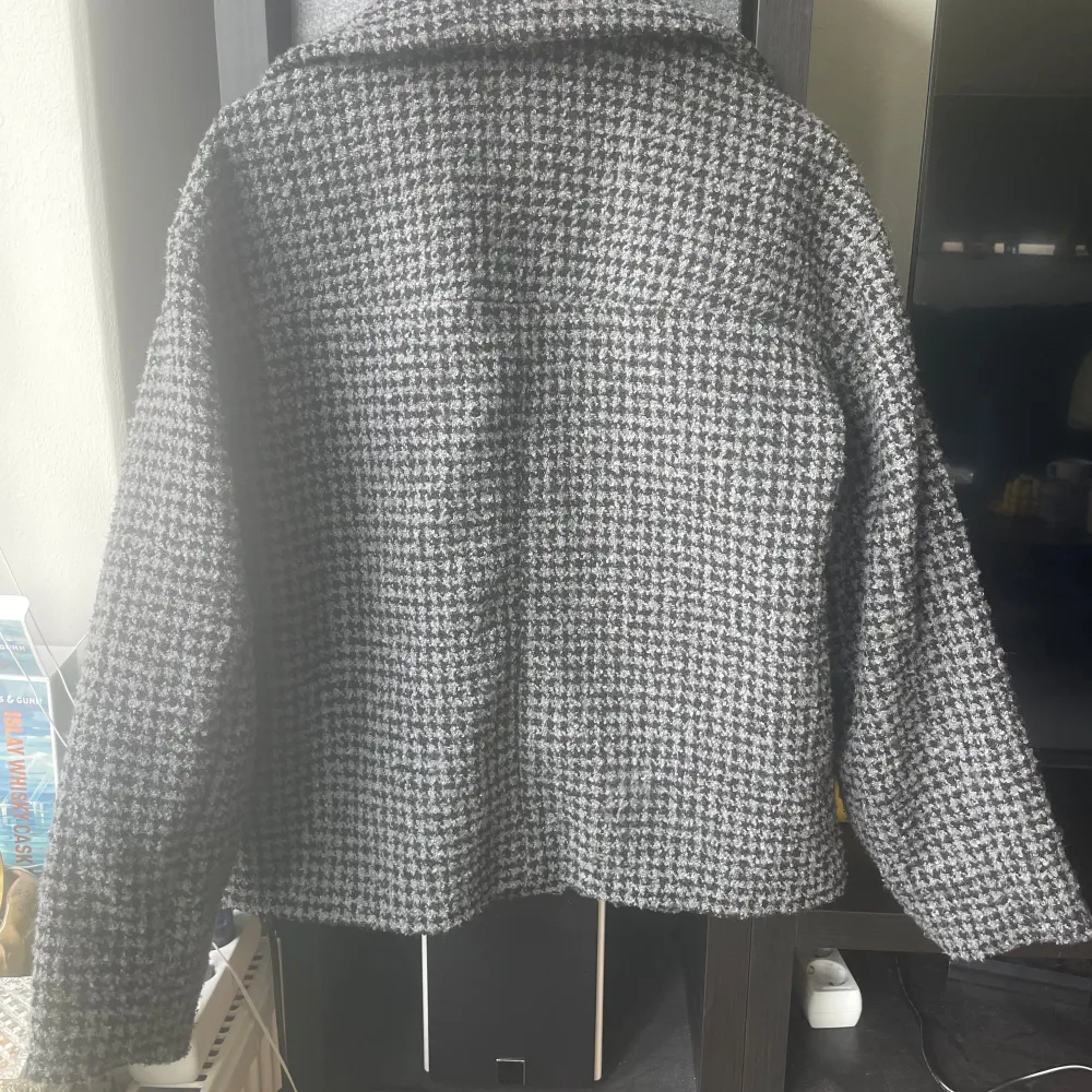 Säljer en stilren grå rutig kappa från Monki. Jackan har en klassisk krage och knäpps med knappar framtill. Perfekt för höst och vår med sin tidlösa design och bekväma passform.. Takit.