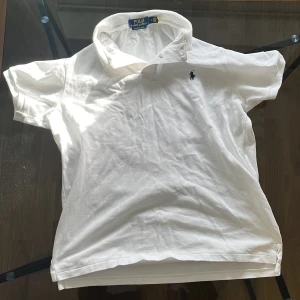 Ralph Lauren piké - Säljer en klassisk vit pikétröja från Ralph Lauren. Tröjan har korta ärmar och en stilren krage. Perfekt för en avslappnad men stilfull look. Storleken är M och passar till 170 och uppåt 👆 