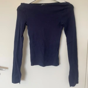 Mörkblå långärmad topp från Gina Tricot - Säljer en stilren mörkblå långärmad topp från Gina Tricot. Toppen har en båt ur ringning och slitsar längst ned på ärmarna. I storlek xs och bra skick. 