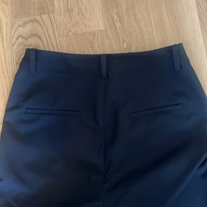 Svarta kostymbyxor - Snygga svarta kostymbyxor med en klassisk design. Byxorna har en botcut passform och är perfekta för en stilren look. De är från bikbok i stl 36.