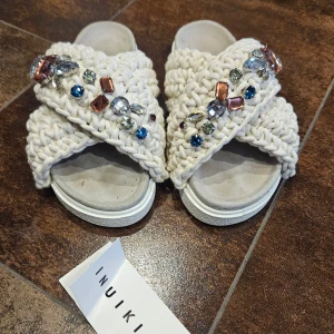 Inuikii sandaler beige - Snygga beige sandaler från Inuikii med glittriga stenar i olika färger. Endast använda en gång, Säljes pga fel storlek. Superfint skick! Nypris 2699 kr. 