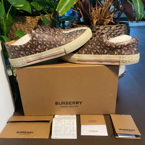 Burberry Canvas Mulitcolor Logo Sneakers - Burberry Canvas sneakers med klassiska mönstret. Stilrena och ikoniska. Nypris idag över 7000kr. Allt på bild medkommer. Storlek 43. Välanvända men i fint skick utan skador. Önskas mer bilder skriv till mig i DM! 