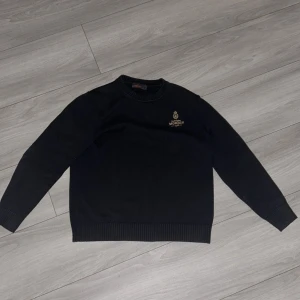 Stickad Morris tröja - En stilren Morris tröja med en klassisk design. Tröjan är stickad med ett unikt märke på bröstet. Storlek L men passar m också. Hör av dig vid minsta lilla funderingar! Kan gå ner i pris