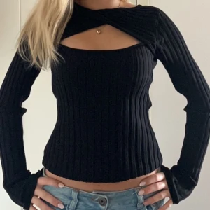 Svart ribbstickad tröja  - Säljer en svart ribbstickad tröja med en twistad öppning som man själv kan bestämma vart man vill ha den 💗