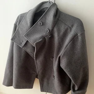 Grå kappa - Snygg grå kappa med hög krage och dubbelknäppning. Köpt från gina tricot i storlek xs. Myckry bra skick. 
