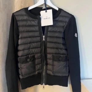 Moncler cardigan  - Förnyar annons! Säljer en svart cardigan från Moncler. I nyskick, taggarna följer med och det finns qr kod.  
