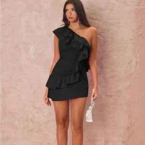 Svart one shoulder volangklänning - Supersnygg svart kortklänning med one shoulder🤩helt ny och aldrig använd. Helt slutsåld 