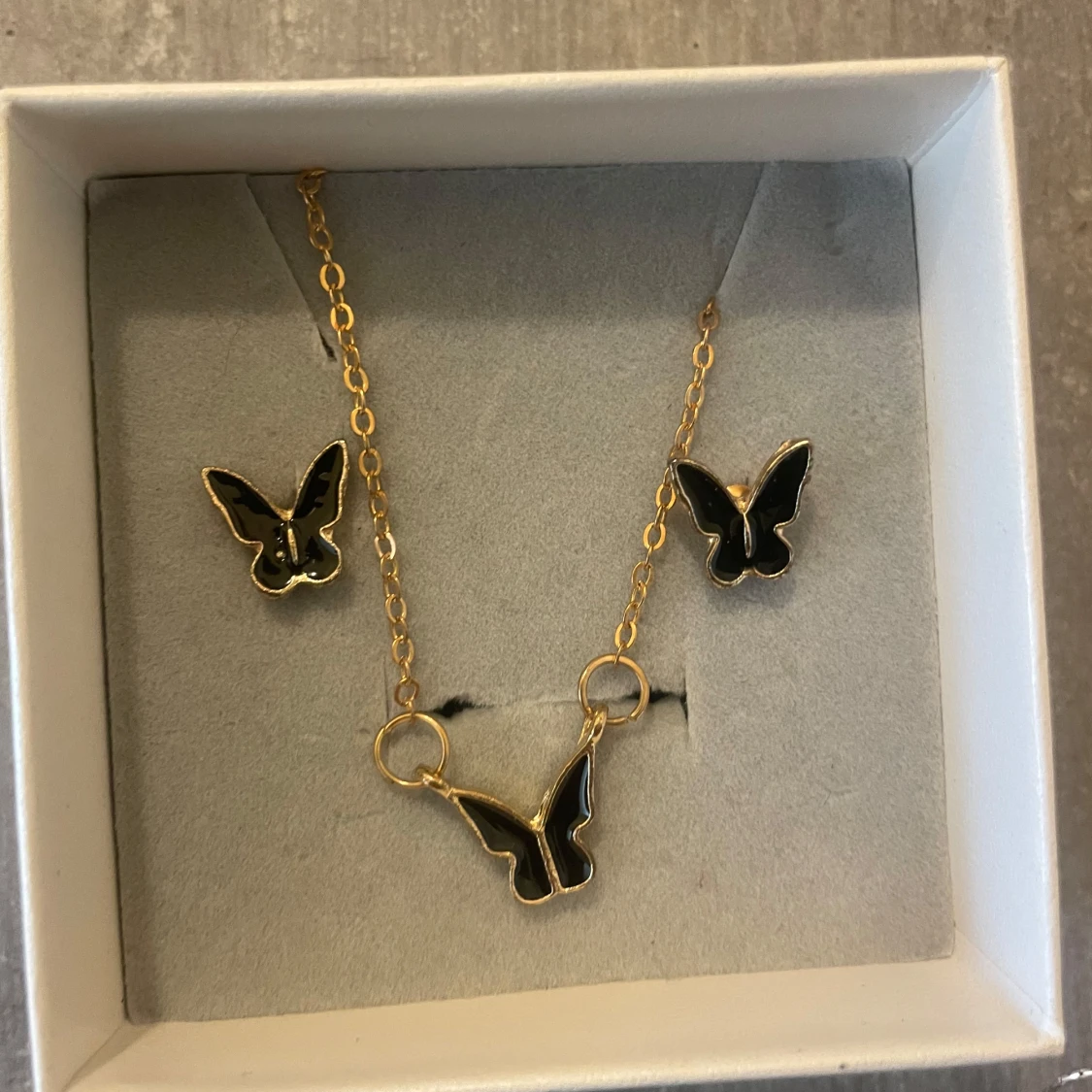 Guldigt fjärilssmyckeset svart