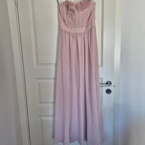 ljusrosa långklänning  - jättesöt ljusrosa långklänning med blommor! klänningen är ifrån h&m och är axelbandslös🌸