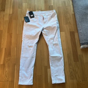  Dsquared jeans  - Snygga vita jeans från Dsquared2 med svart DSQD2-tryck på bakfickan. Passar dig om du är runt 160 cm lång.