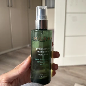 Hickap Preppy Prime Setting Spray - Grön genomskinlig flaska med silvrig pump, Hickap Preppy Prime Setting Spray ger en matt finish och är 100% vegansk. Passar alla hudtyper och används för att fixera sminket. Enkel att spraya över ansiktet för en fräsch look och får ditt smink att hålla längre. Har inte använt den så mycket som ni kan se på bilderna men den är sjukt bra! 