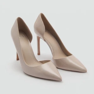Beige pumps med spetsig tå och klack - Stilrena pumps i beige med glansig finish och spetsig tå. Skorna har hög klack och en klassisk siluett som ger ett elegant intryck. Helt nya med prislapp kvar  verkligen supersnygga, men tyvärr för stora för mig.