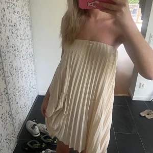 Så fin bandueklänning💛💛🤗 - Superfin kort plisserad klänning i champagnefärg. Är egentligen en kjol men går att användas som klänning på bilderna🌸inga defekter