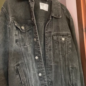 Svart jeansjacka från Bershka - Säljer en svart jeansjacka från Bershka i storlek S. Jackan har klassisk denimlook med knappar framtill, två bröstfickor med lock och knapp samt sidofickor. Skriv för fler frågor/bilder❤️