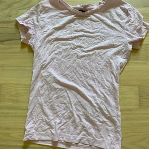 Ljusrosa basic t-shirt i bomull - Enkel och stilren ljusrosa t-shirt i mjuk bomull. Klassisk rund halsringning och korta ärmar. Passar till allt och är superbekväm att bära hela dagen. Passform: tight 