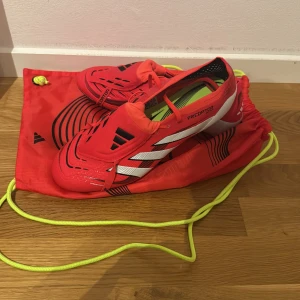 Adidas Predator fotbollsskor - Säljer ett par helt oanvända Adidas Predator fotbollsskor, fick dem av laget men kan inte ha adidas. Allt orginal  Kommer med matchande röd påse. Hör av er vid funderingar 