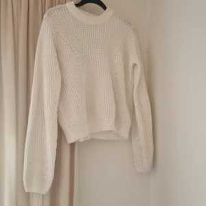 Vit stickad tröja från XOXO friends - Supermysig vit stickad tröja från XOXO friends med snyggt mönsterstickat fram och bak. Tröjan har rund halsringning, ribbade muddar och långa ärmar. Perfekt för lager på lager under kyliga dagar.