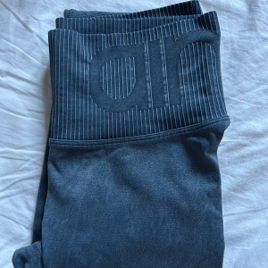  Aim'n ocean washed leggings - Snygga mörkgrå ocean washed leggings från Aim'n med hög midja och ribbade detaljer i midjan och längs benen. Stretchigt material som sitter tight och bekvämt, perfekt för träning eller chill. Diskret Aim'n-logga framtill på midjan.