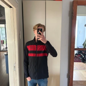 J.Lindeberg vindjacka - Snygg marinblå vindjacka från J.Lindeberg med diskret logga. Tillverkad i lätt tyg, bra vår/höst jacka som även passar bra på golfbanan. Storlek M och sitter som vanligt. Hör av dig vid minsta fundering. 