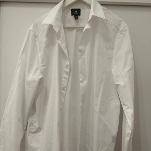 Vit skjorta från H&M Regular Fit M - Klassisk vit skjorta från H&M i regular fit med snygg krage och knäppning framtill. Skjortan är tillverkad i bomull och har långa ärmar. Perfekt för en clean och stilren look.