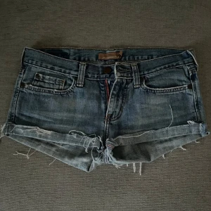 Jeansshorts med fransig kant - Snygga blå jeansshorts från Abercrombie & Fitch med fransig kant och klassisk femficksdesign. Shortsen har låg midja och slitna detaljer för en avslappnad vibe. Perfekta för varma sommardagar och festivalhäng.