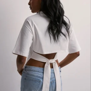 Vit topp med knyt i ryggen - Säljer en vit topp med korta ärmar och snygg knytning i ryggen. 