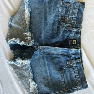 Rag & Bone jeansshorts med fransar - Snygga blå jeansshorts från Rag & Bone i modellen Margaux Short. De har råa fransiga kanter, klassisk femficksdesign och dragkedja. Perfekta för sommardagar och ger en avslappnad vibe. Tillverkade i 100% bomull för en skön känsla. Nypris 1700kr 