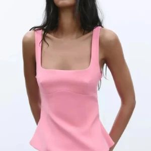 Rosa topp med rosett och öppen rygg - Supersöt rosa topp med breda axelband, fyrkantig urringning och figurnära passform. Baksidan har en stor rosett, dragkjedja och öppen rygg som ger en extra cool touch. Aldrig använd och har kvar lappen ! 