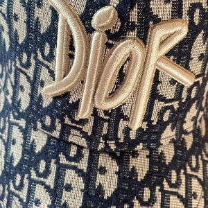 Dior keps i blått monogram - Snygg keps från Dior med ikoniskt blått och vitt monogrammönster. Stor broderad Dior-logga framtill i beige. Justerbar rem baktill med metallspänne där Dior är ingraverat. Kepsen är tillverkad i ett vävt material som känns lyxigt och trendigt.